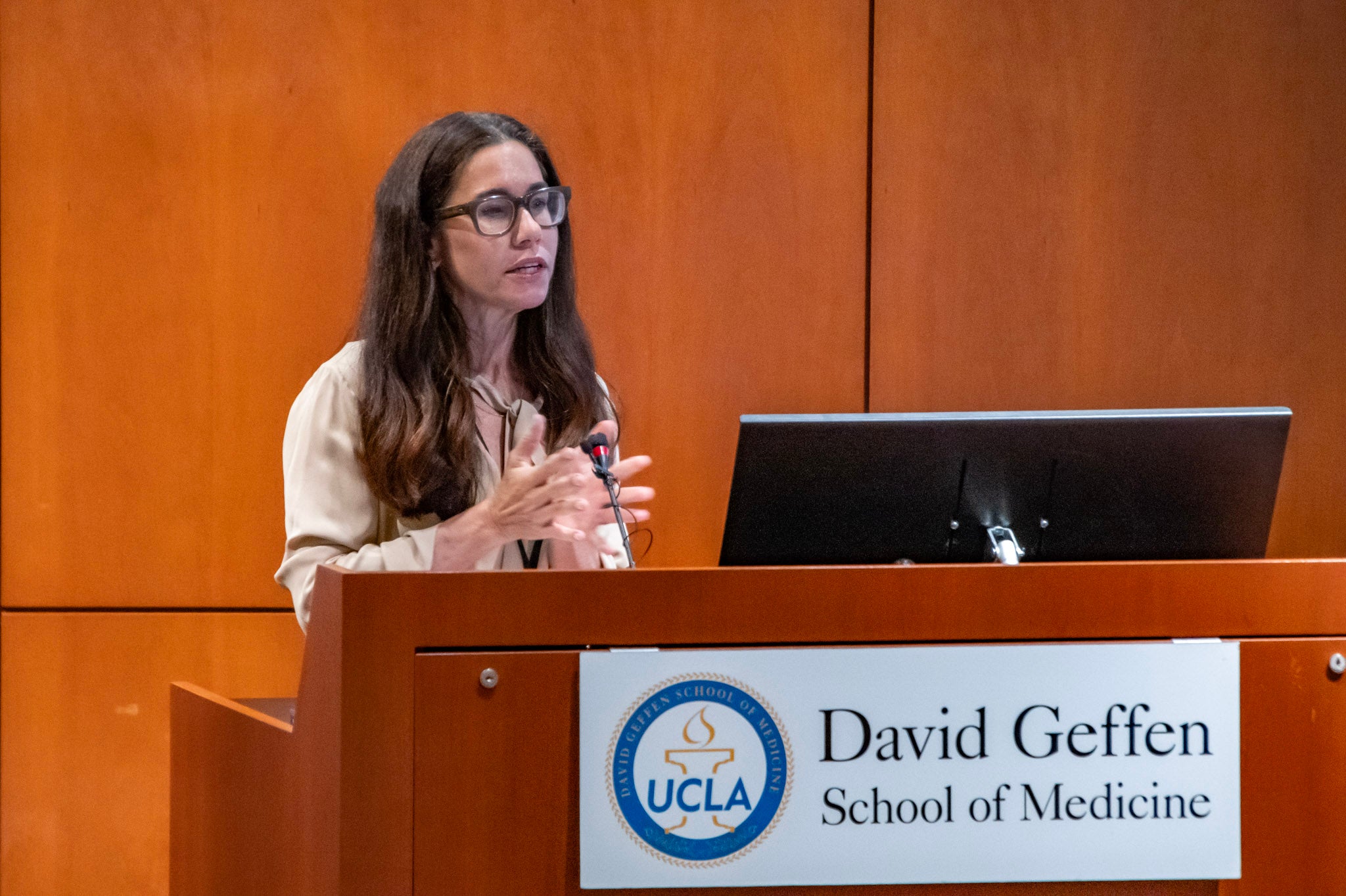 Lauren Arborio, Co-Founder of Connections in Recovery, speaks at the podium for the UCLA & CiR Los Angeles Mental Health & Addiction Symposium